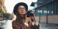 Hobby photographer concept. Outdoor lifestyle portrait of pretty woman in sun city in Europe with camera travel photo Royalty Free Stock Photo