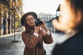 Hobby photographer concept. Outdoor lifestyle portrait of pretty young woman in sun city in Europe with camera travel photo Royalty Free Stock Photo