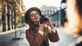 Hobby photographer concept. Outdoor lifestyle portrait of smiling  woman having fun in sun city in Europe with camera travel Royalty Free Stock Photo