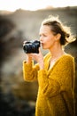 Outdoor lifestyle portrait of young woman taking photos with her mirrorless camera Royalty Free Stock Photo