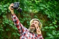 Hobby and professional occupation. Use camera. Creating content for blog. Bearded man hipster taking photo. Photographer