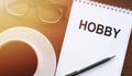 HOBBY - text on paper with cup of coffee and glasses on wooden background in sinlight Royalty Free Stock Photo