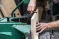 Hobby wood concept. Cropped photo of cabinetmaker handyman tradesman hands install wooden plank on woodworking machine make