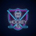 Hockey championship neon sign with hockey sticks, puck and goalkeeper helmet in shield frame Ice hockey competition logo Royalty Free Stock Photo