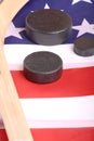 Hockey equipment including a stick and puck on an American flag to infer a patriotic American sport.