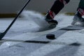 A hockey player slides across the arena and hits the puck with a hockey stick, cutting the ice into powder. Match on ice Royalty Free Stock Photo