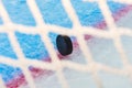 Hockey puck through goal net Royalty Free Stock Photo