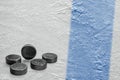 Hockey pucks and a fragment of the ice arena with a blue line