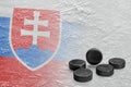 Hockey pucks and the image of the Slovak flag on ice