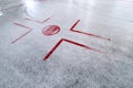 Hockey rink with faceoff spot on freshly resurfaced ice with marks of water