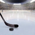 Hockey Stick and Puck on Ice of Crowded Arena