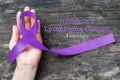 Hodgkin`s lymphoma and testicular cancer awareness violet ribbon symbolic bow color on helping hand support isolated