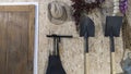 Hoe, shovel, harrow and hat beside wooden door Royalty Free Stock Photo