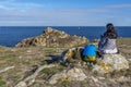 Woman tourist sitting in the rock acing to the Ocean, Cape Vieux Chateaux, Brittany, France