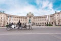 Hofburg Palace and Heldenplatz with a passing carriage with a pair of horses, Vienna, Austria Royalty Free Stock Photo