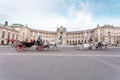 Hofburg Palace and Heldenplatz with a passing carriage with a pair of horses, Vienna, Austria Royalty Free Stock Photo