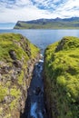 Hofsa river steam falling down to Mjoifjordur waters of Atlantic Ocean Royalty Free Stock Photo