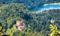 Hohenschwangau castle and Schwansee lake in Bavarian Alps, Germany. Beautiful landscape of Alpine mountain with famous castle in Royalty Free Stock Photo