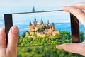 Hohenzollern Castle on mountain top, Germany. Tourist taking photo of famous castle by cell phone Royalty Free Stock Photo