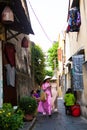 HOI AN, QUANG NAM, VIETNAM, April 26th, 2018: Vietnamese women wearing ao dai. Street view with old houses in Hoi An ancient town.