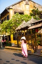 HOI AN, QUANG NAM, VIETNAM, April 26th, 2018: Vietnamese women wearing ao dai. Street view with old houses in Hoi An ancient town.