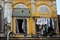 Clothes hanging out of a window in the yellow walls of an old heritage shop house in the town of Hoi