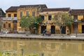 An old woman pushes a cart along the Thu Bon River in Hoi An