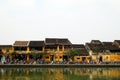 The embankment of Thu Bon River with yellow buildings and traditional wooden boats. Royalty Free Stock Photo