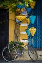 Street view of a blue door with yellow lanterns and a bike in Vietnam Hoi An old town