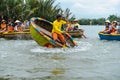 A Vietnamese man is dancing on colorful basket boat