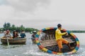 A Vietnamese man is dancing on colorful basket boat Royalty Free Stock Photo