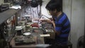 Hoi An, Vietnam - May 10, 2018: Handicrafts man repearing the parts at fair of crafts and jewelery, ceramics . Asian