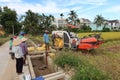 A group of people next to a rice harvester during the first rice harvest of 2021 in Hoi An, Vietnam