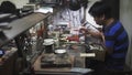 Hoi An, Vietnam - May 10, 2018: Handicrafts man repearing the parts at fair of crafts and jewelery, ceramics . Asian