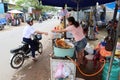 A woman delivers an order to a young customer at her stall selling banana pancakes on one of the streets in Hoi An`s Ba Le market