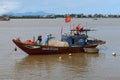 Three men in a fishing boat moored in the Duy Hai fishing port. Thu Bon river mouth. Hoi An, Vietnam Royalty Free Stock Photo