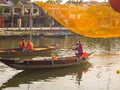 HOIAN, VIETNAM, SEPTEMBER, 04 2017: Unidentified people in the traditional boats in front of ancient architecture in Hoi