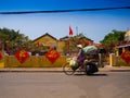 HOIAN, VIETNAM, SEPTEMBER, 04 2017: Unidentified woman biking in the street view with old houses, and colorful lanters