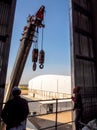 Hoist of crane at the window of industrial plant