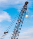 The Hoisting Crane With Pulley And Hook In Construction Site Against Blue Sky Background.