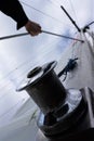 Hoisting tarpaulin at the mast on a sailboat. Active sport that moves on wind power by catching wind in the sails. Royalty Free Stock Photo