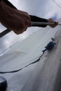 Hoisting tarpaulin at the mast on a sailboat. Active sport that moves on wind power by catching wind in the sails. Royalty Free Stock Photo