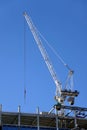 Hoisting tower crane on the top section being constructed of modern high skyscraper building