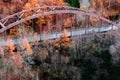 Hokkaido highway red truss bridge with autumn foliage yellow tree forest, aerial view Royalty Free Stock Photo