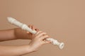 Hold fipple flute with both hands and pinch holes closeup, beige background. Woodwind musical instrument. Royalty Free Stock Photo