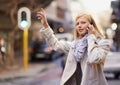 Hold on, Im catching a taxi. a young woman hailing a cab while talking on her cellphone.