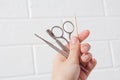 Hold manicure tools in your hand. Nail care, procedure, nail salon. Tweezers, wire cutters, pusher, orange tree stick, scissors, Royalty Free Stock Photo