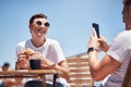 Hold still while a take a photo. a cheerful young woman getting her picture taken by her boyfriend outside while they