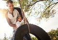 Hold on tight. a happy father pushing his daughter on a tyre swing. Royalty Free Stock Photo