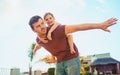 Hold on tight now. Portrait of a happy little girl and her father playing together in their backyard at home. Royalty Free Stock Photo